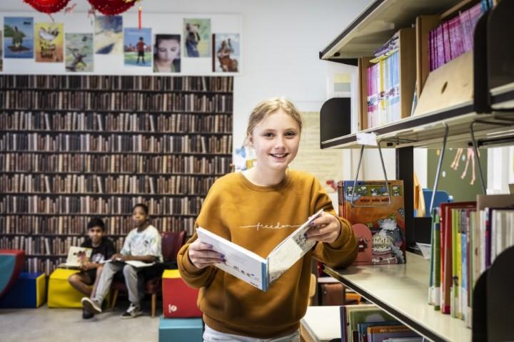 Meisje leest een boek uit de bibliotheek van Leerexpert Jozef van Poppelstraat.